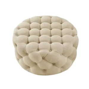 Beige tufted round ottoman on white background.