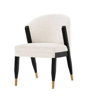 Modern beige chair with black legs and gold tips.