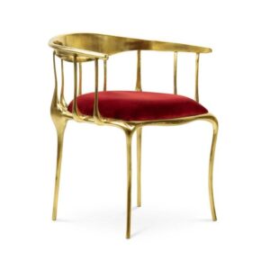 Elegant gold chair with red velvet seat.