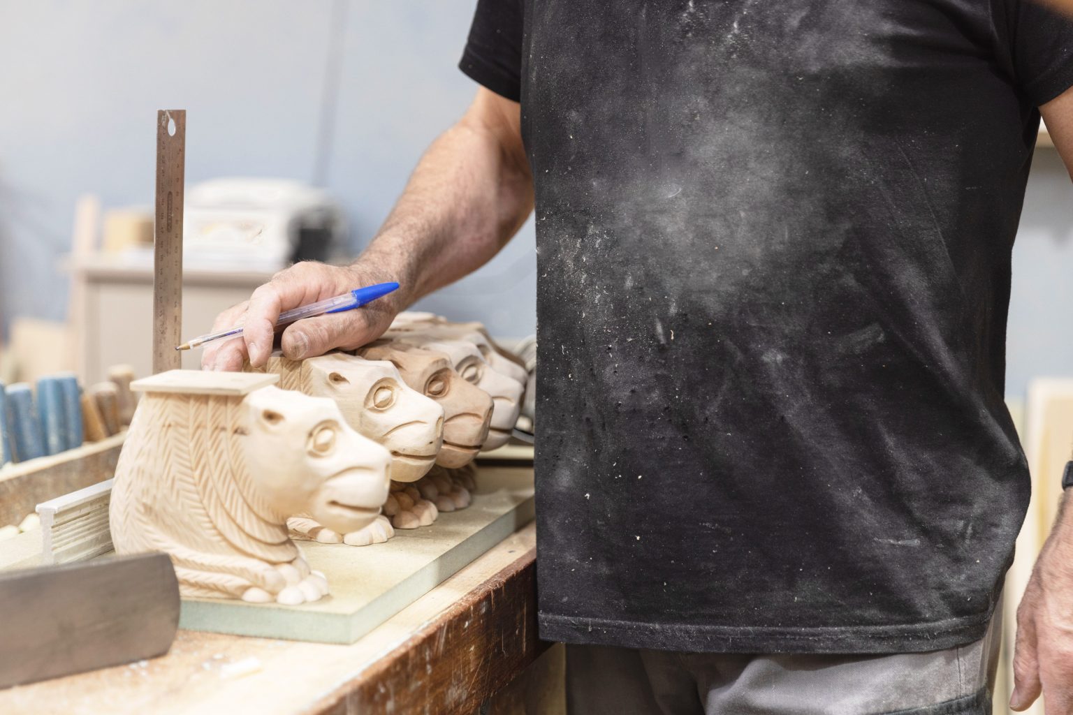 Carver sculpting animal-shaped wooden designs