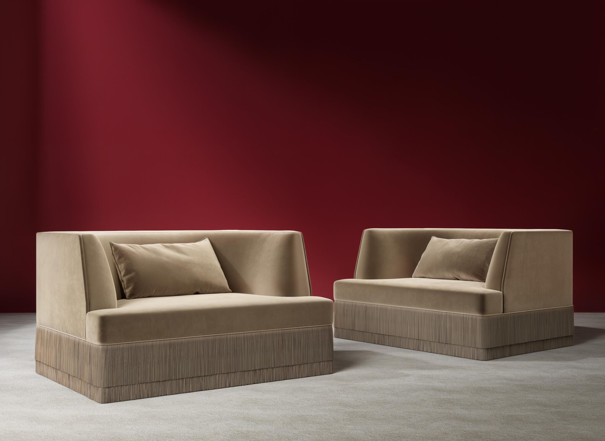Beige velvet sofas with red wall background.